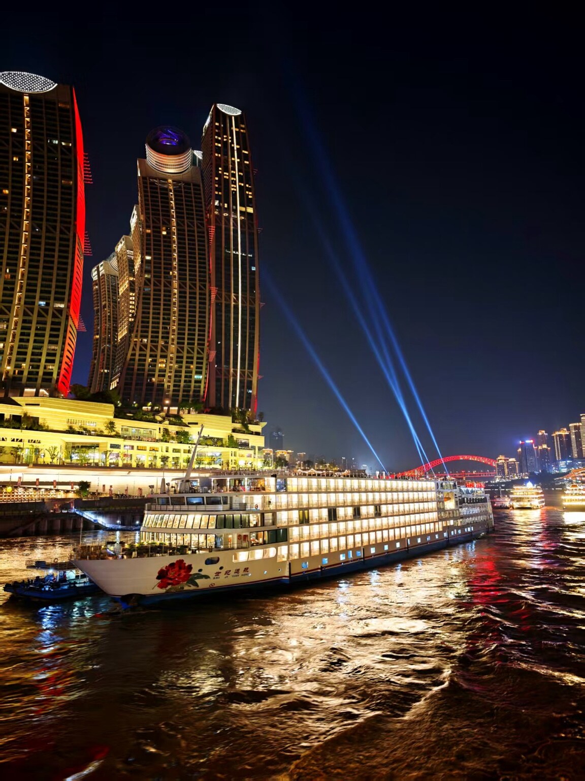 A Century Cruising ship sailing past Chongqing's illuminated skyline at night