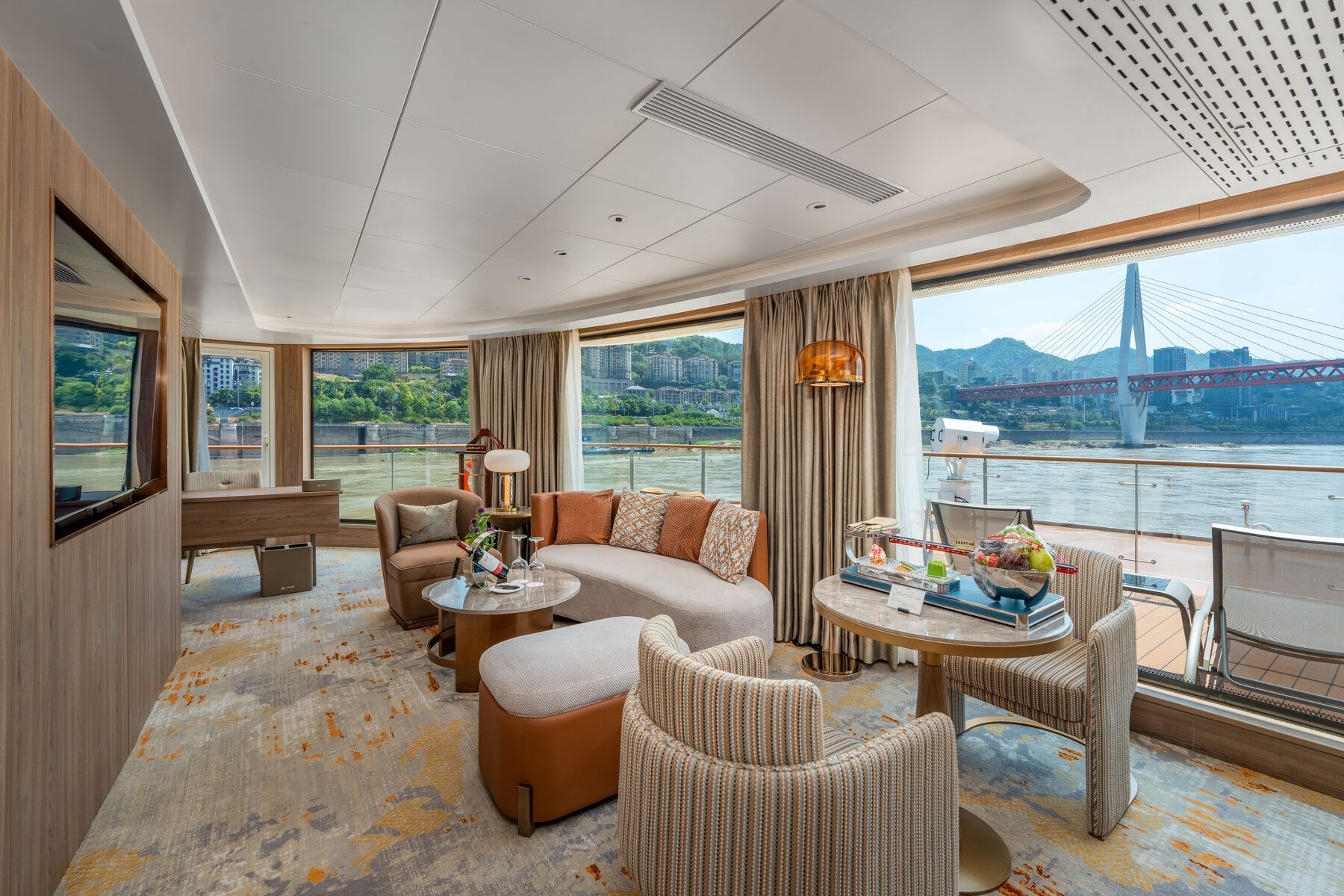 A spacious Century Voyage suite with a private balcony overlooking the river