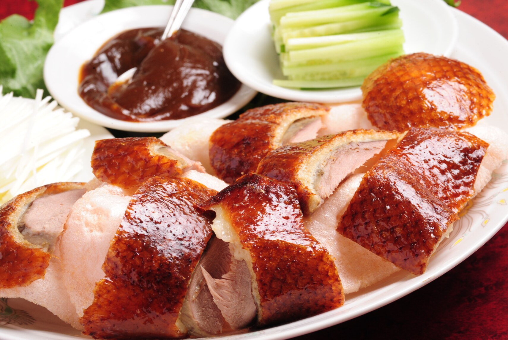 Sliced Peking duck served with pancakes, cucumber, and sauce
