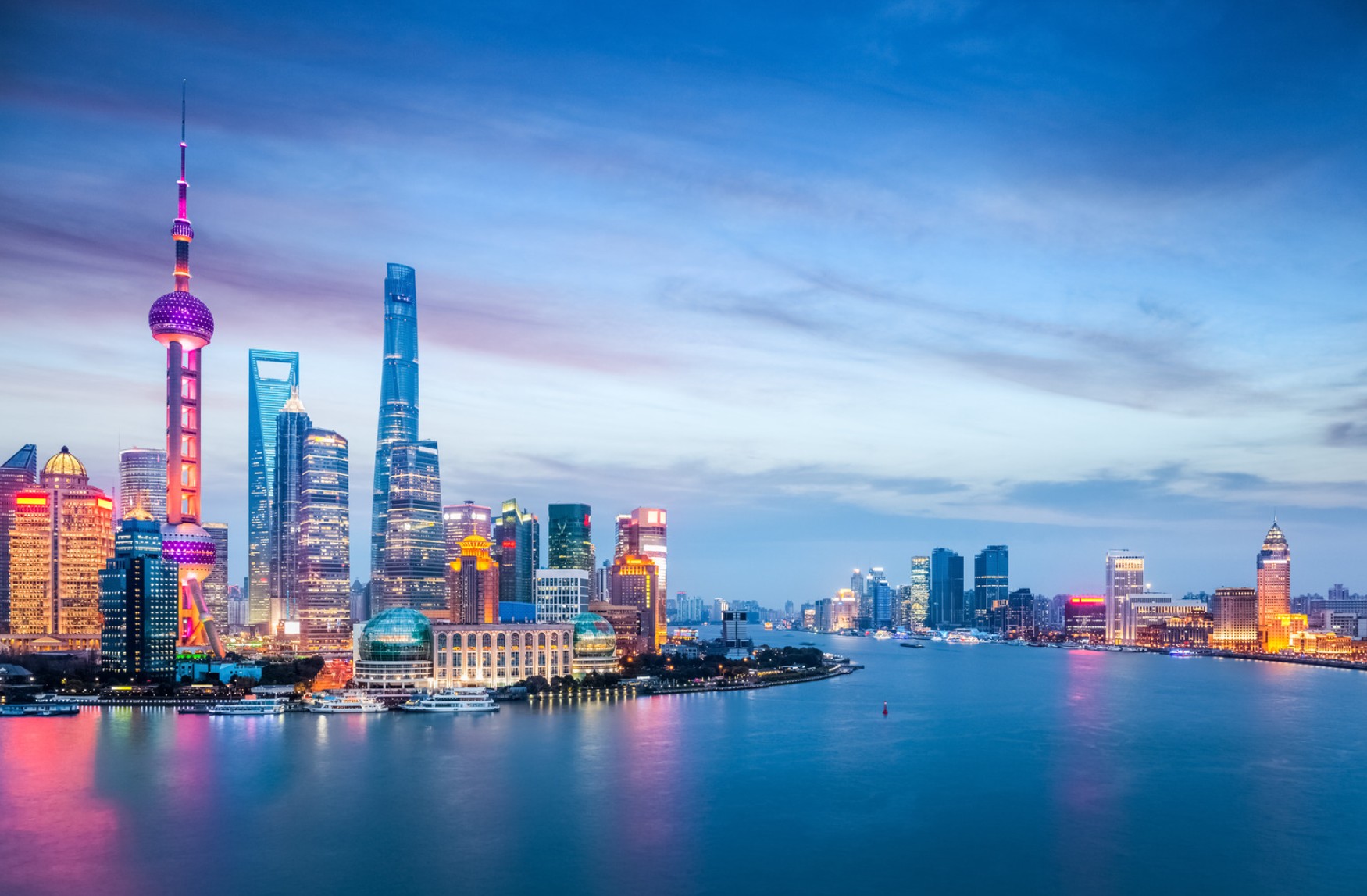 Shanghai’s illuminated skyline on both banks of the Huangpu River at dusk