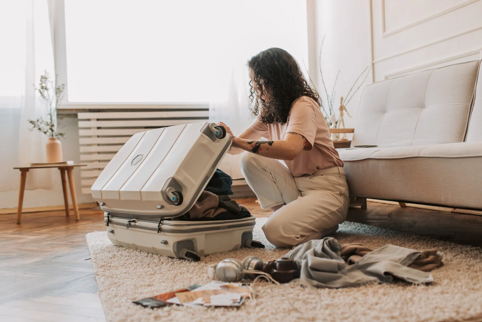 A traveler packing clothing and essentials into a suitcase