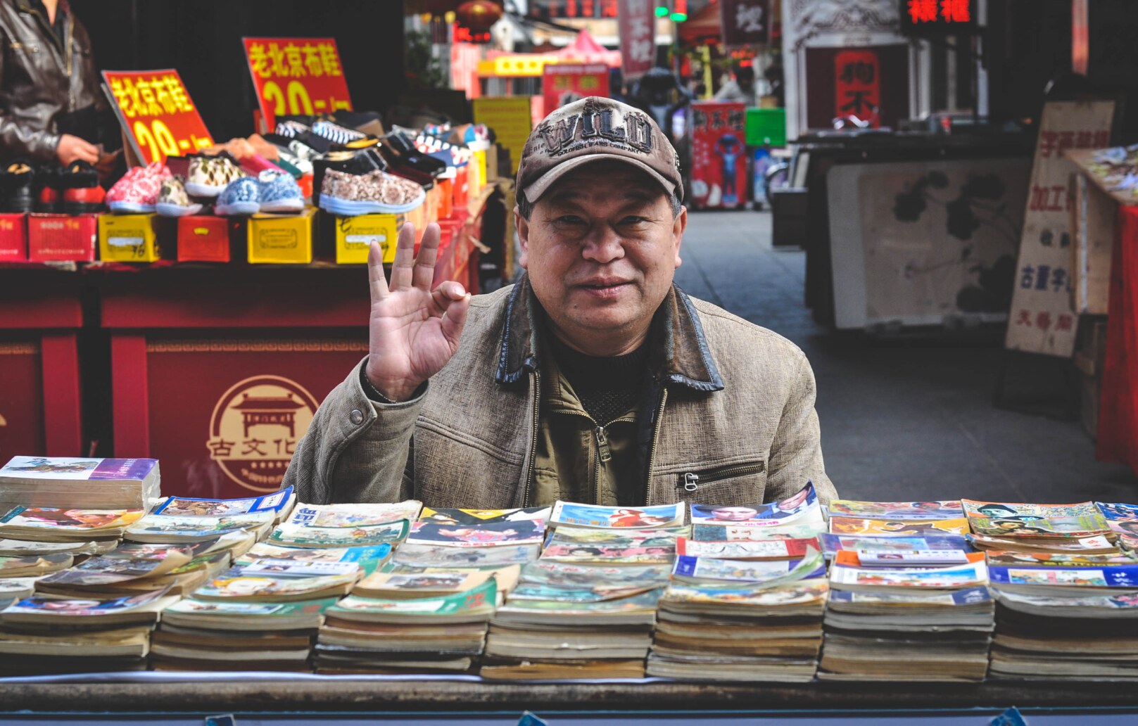 A smiling street vendor greeting the camera at his book stall