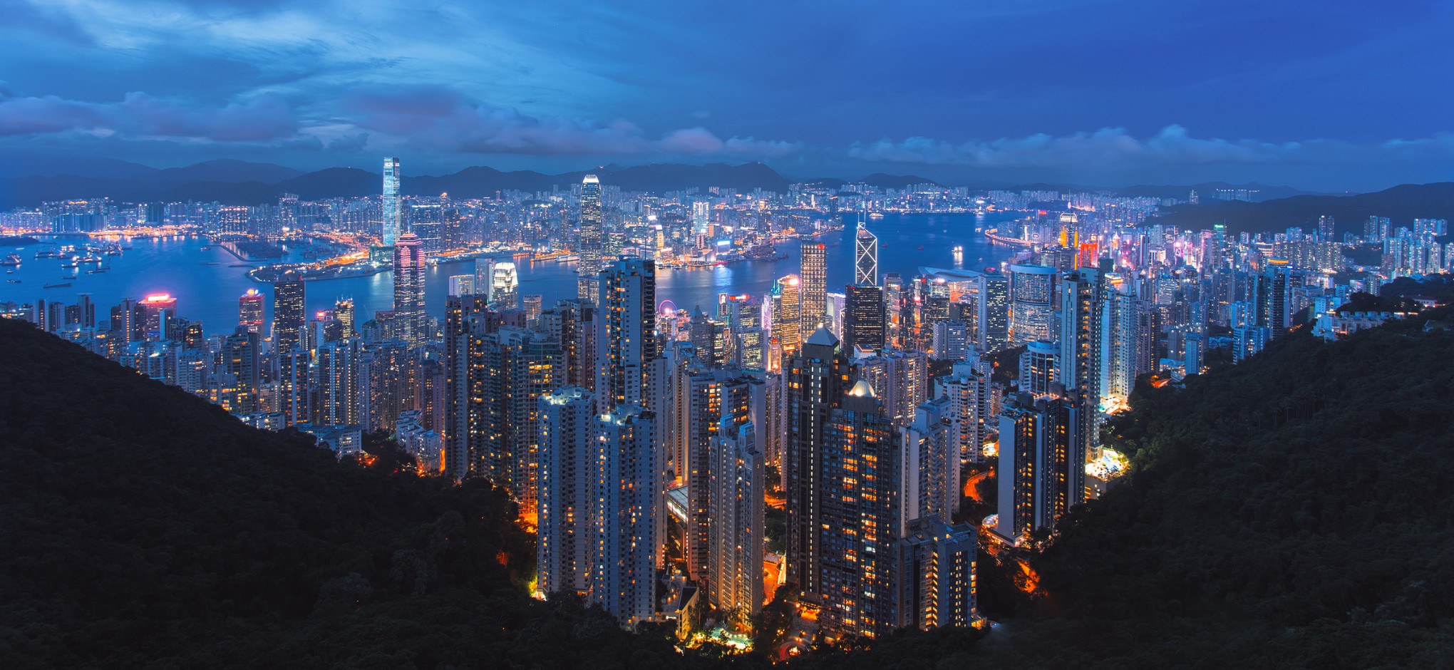 Hong Kong’s skyline and harbor illuminated at dusk