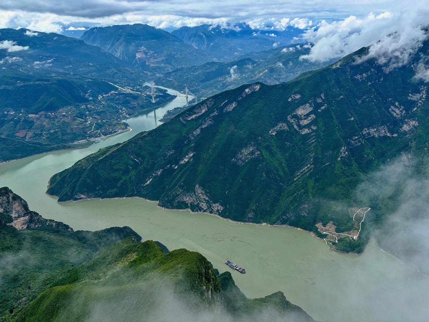 The Yangtze River winding through steep green mountains and low clouds
