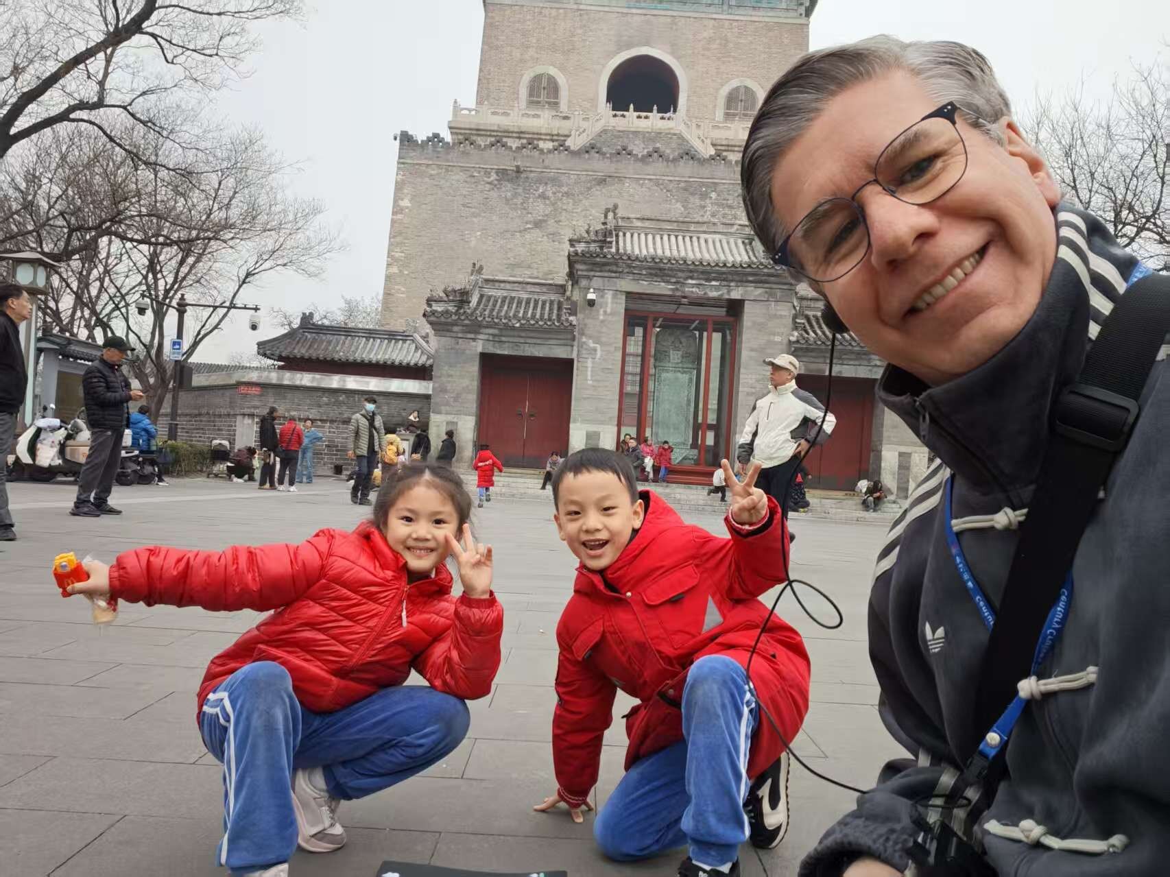 Steve smiling with two children during a visit in China