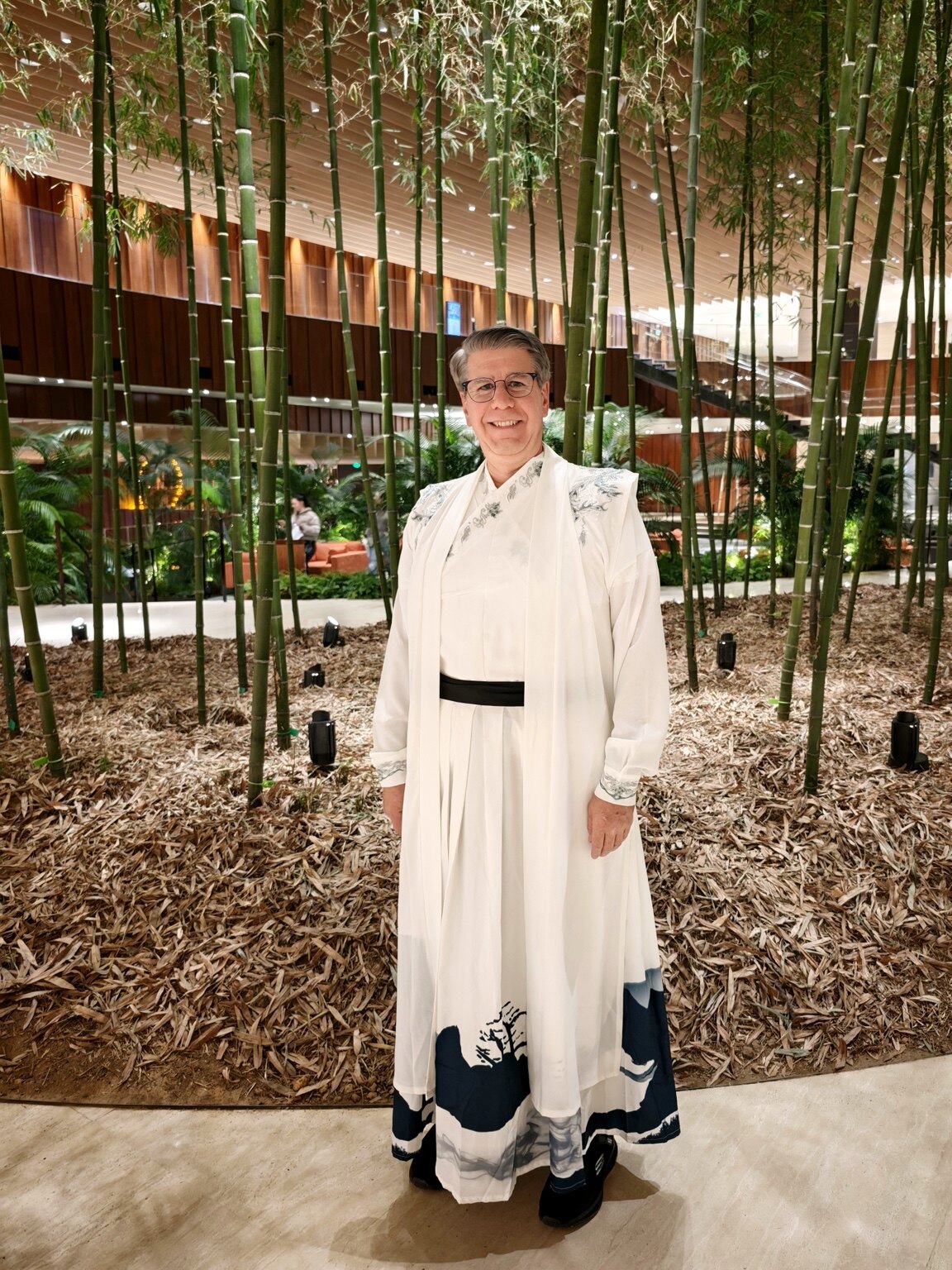 Steven Simao wearing traditional Chinese dress in a bamboo garden